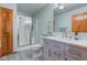 Well-lit bathroom with shower, vanity, and wood-look flooring at 7911 Bentley Commons Dr, Indianapolis, IN 46259