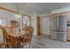 Bright dining room featuring wood table and chairs set with luxury vinyl flooring and stainless steel refrigerator at 7911 Bentley Commons Dr, Indianapolis, IN 46259