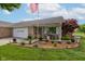 Charming brick home featuring a cozy front porch and landscaped garden, complete with an American flag at 7911 Bentley Commons Dr, Indianapolis, IN 46259