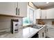 Bright kitchen featuring white cabinets, stainless steel sink, and white marble-style countertop at 8025 Meadow Ln, Indianapolis, IN 46227