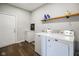 Laundry room with new washer and dryer, a wooden shelf, and a storage cabinet at 8025 Meadow Ln, Indianapolis, IN 46227