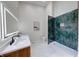 Contemporary bathroom with double sinks, illuminated mirrors, and a stand-up shower with green tile at 8178 Foxchase Cir, Indianapolis, IN 46256
