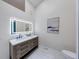 Bathroom features a double vanity, illuminated mirror, modern fixtures, and art on the wall at 8178 Foxchase Cir, Indianapolis, IN 46256