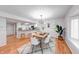 Modern dining room featuring contemporary light fixture, wood floors, and an open layout to the kitchen at 8178 Foxchase Cir, Indianapolis, IN 46256