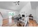 Bright living room featuring hardwood floors, a ceiling fan, a fireplace, and sliding glass doors to a patio at 8178 Foxchase Cir, Indianapolis, IN 46256
