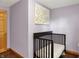 Purple Bedroom features dark hardwood flooring, a crib, and a cute art piece on the wall at 8760 Big Bend Rd, Martinsville, IN 46151