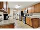 Functional kitchen with stainless steel appliances, wood cabinets, and a view into the laundry area at 8760 Big Bend Rd, Martinsville, IN 46151
