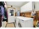 Laundry room featuring front load machines, wood paneling, and storage at 8760 Big Bend Rd, Martinsville, IN 46151