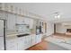 Bright eat-in kitchen with white cabinets and views into a cozy living room with a fireplace at 904 Dreamy St, Greenwood, IN 46142