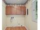 Functional laundry room with wooden cabinets, utility connections, and a window for natural light at 904 Dreamy St, Greenwood, IN 46142