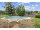 Backyard in-ground swimming pool surrounded by a metal fence, lush greenery and a concrete base at 904 Dreamy St, Greenwood, IN 46142