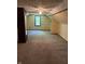 Spacious room featuring a ceiling fan, large window, and neutral carpeting at 9168 S State Road 9, Flat Rock, IN 47234