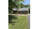 Charming brick home featuring a well-maintained lawn, mature trees, and decorative fountain, blending comfort with natural beauty at 9168 S State Road 9, Flat Rock, IN 47234