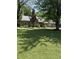 Traditional brick home boasts a lush front lawn, mature trees, and a welcoming facade, offering a serene living environment at 9168 S State Road 9, Flat Rock, IN 47234