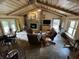 Spacious living room featuring a vaulted ceiling, wood beams, a stone fireplace, and ample seating for Gathering and guests at 9168 S State Road 9, Flat Rock, IN 47234