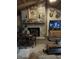 Cozy living room features a stone fireplace, rustic decor, and a large TV, creating a warm and inviting atmosphere at 9168 S State Road 9, Flat Rock, IN 47234
