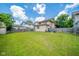 Large, grassy backyard with wooden fence, shed, and views of the home's exterior at 917 W 8Th St, Anderson, IN 46016