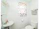 A bright bathroom has a classic white sink and toilet under a butterfly-themed window at 917 W 8Th St, Anderson, IN 46016
