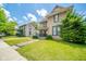 A two-story home boasts curb appeal with a manicured lawn and lush greenery at 917 W 8Th St, Anderson, IN 46016