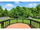 Wooden deck with black railings overlooks the grassy backyard with mature trees providing shade at 9265 Brunson Run, Indianapolis, IN 46256