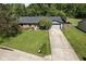 Single-story home featuring brick accents, an attached garage, and a well-maintained front yard with mature trees at 9265 Brunson Run, Indianapolis, IN 46256