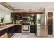 The kitchen features stainless steel appliances, granite countertops, and dark cabinetry with stone backsplash at 9265 Brunson Run, Indianapolis, IN 46256