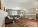 A cozy living room with hardwood floors, a sectional sofa, and abundant natural light from the large window at 9265 Brunson Run, Indianapolis, IN 46256