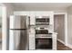 Bright kitchen with stainless steel appliances, white cabinetry, and wood-look flooring at 946 N Temple Ave, Indianapolis, IN 46201