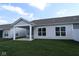 Backyard view featuring a covered porch and well-maintained lawn at 10604 Maidenhair Dr, Indianapolis, IN 46239