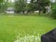 Spacious backyard showcasing a well-manicured lawn, a split rail fence, and garden beds at 1067 Barley Cir, Carmel, IN 46032