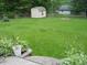 Lush backyard featuring a charming shed, green lawn, and landscaping with a stone patio at 1067 Barley Cir, Carmel, IN 46032