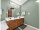 Bathroom with a double sink vanity with wood cabinets and a large mirror at 1067 Barley Cir, Carmel, IN 46032