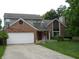 Charming two-story home with well-manicured lawn and a two-car garage and brick facade with a basketball hoop at 1067 Barley Cir, Carmel, IN 46032