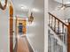 Hallway leading to the kitchen with a staircase in view plus carpet runner and baby gate at 1067 Barley Cir, Carmel, IN 46032