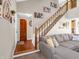 A spacious living room and hallway with a comfortable sectional sofa, an open staircase, and wood floors at 1067 Barley Cir, Carmel, IN 46032