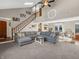 Open-concept living room with a soaring staircase, lots of natural light, and a comfortable gray sectional sofa at 1067 Barley Cir, Carmel, IN 46032