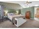 Well-lit primary bedroom featuring a king-size bed, a ceiling fan, and skylights at 1067 Barley Cir, Carmel, IN 46032