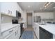 Modern kitchen with white countertops and cabinets, complemented by stainless steel appliances and dark hardware at 11663 Winnower, Noblesville, IN 46060