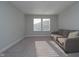 Bright living room features a gray sofa, carpet and natural light creating a cozy and inviting space at 11663 Winnower, Noblesville, IN 46060