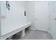Mud room features a white bench with hooks, providing a convenient and organized space for storing outdoor essentials at 11663 Winnower, Noblesville, IN 46060