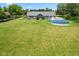 Lush backyard featuring an above-ground swimming pool and plenty of green space surrounded by mature trees at 1439 E Mckenzie Rd, Greenfield, IN 46140