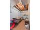 Unfinished basement area with wall-mounted shelving, exposed ceiling, carpeted floors, and blue-painted walls at 1439 E Mckenzie Rd, Greenfield, IN 46140