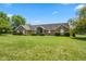 Charming single story home with a lush green lawn and manicured bushes at 1439 E Mckenzie Rd, Greenfield, IN 46140