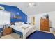A bedroom with a bright blue accent wall, matching carpet, and a king-sized bed at 1439 E Mckenzie Rd, Greenfield, IN 46140