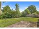 The backyard has lush, mature bushes and trees along with a patio and partial wood fence at 1540 Brook Pointe Dr, Indianapolis, IN 46234