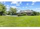 Spacious backyard with a pool, manicured lawn, and lush landscaping, perfect for outdoor entertaining at 1682 S Fox Cove Blvd, New Palestine, IN 46163
