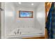 Bathroom with tiled whirlpool tub under a window and wood trim at 1682 S Fox Cove Blvd, New Palestine, IN 46163