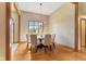 Dining room featuring hardwood floors, statement lighting, and views of the front yard at 1682 S Fox Cove Blvd, New Palestine, IN 46163