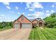 Beautiful brick home showcasing an attached three-car garage and meticulously maintained lawn at 1682 S Fox Cove Blvd, New Palestine, IN 46163