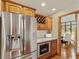Kitchen view with stainless steel refrigerator, granite countertops, and wood cabinets with wine storage at 1682 S Fox Cove Blvd, New Palestine, IN 46163
